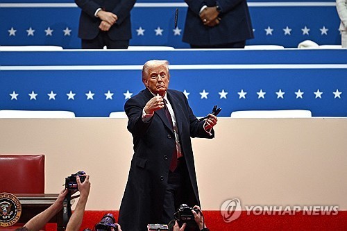 트럼프 미 대통령이 행정명령 서명이 끝난 뒤 서명에 사용한 펜을 지지자들에게 던지고 있다. /사진=연합뉴스