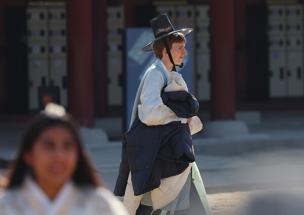 서울 낮기온이 오르면서 서울 경복궁을 찾은 관광객이 외투를 손에 걸친 채 궁궐을 돌아보고 있다. /사진=연합뉴스