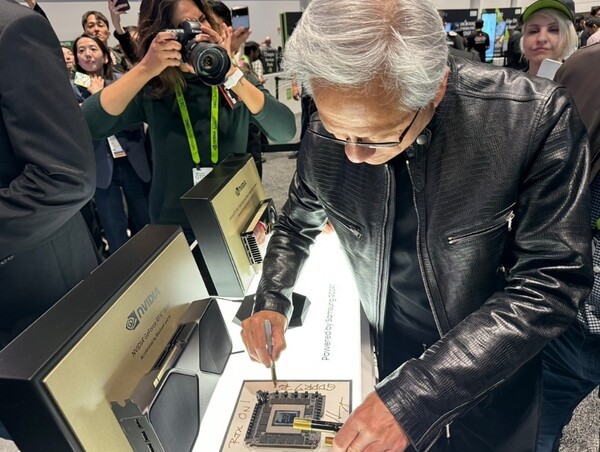 젠슨 황 엔비디아 최고경영자(CEO)가 연례 개발자 콘퍼런스 GTC 2025 넷째 날인 20일(현지시간) 삼성전자 부스를 찾아 그래픽 메모리에 친필 사인을 하고 있다.  / 사진=연합뉴스