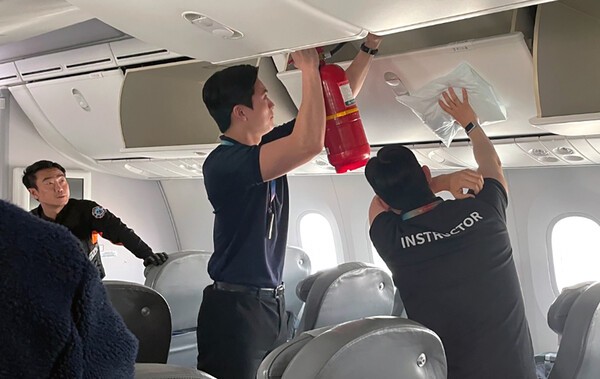 지난 18일 인천국제공항 내에 위치한 에어프레미아 항공기안에서 훈련에 참석한 에어프레미아 승무원들이 기내선반의 화재진압 훈련을 진행하고 있다./사진=에어프레미아