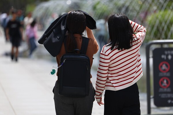서울 한낮 기온이 26도까지 치솟으며 초여름 날씨를 보인 지난 21일 서울 종로구 광화문광장에서 시민들이 겉옷이나 손으로 햇빛을 피하며 이동하고 있다./사진=연합뉴스