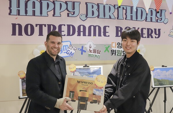 30일 열린 노틀담베이커리 오픈 2주년 축하 이벤트 기념 사진 촬영을 하고 있는 GM 해외사업부문 품질 및 운영 혁신 부문 아달베르토 토레알바(Adalberto Torrealba) 부사장(왼쪽)과 슬로건 공모전에서 수상한 GM 한국사업장 직원./사진=GM 한국사업장