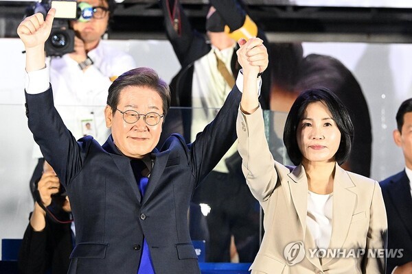 이재명 대통령과 부인 김혜경 여사가 당선이 확실시된 4일 새벽 서울 여의도 국회 인근에서 당 주최로 열린 국민개표방송 행사에 참석해 시민들을 향해 두 팔을 들어 올려 인사하고 있다. /사진=연합뉴스