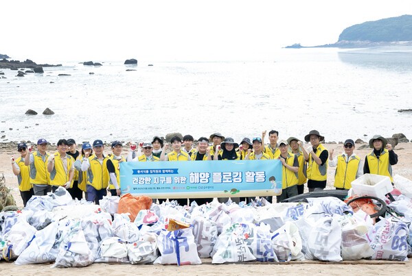 동서식품이 지난 19일 인천 무의도 해안가에서 플로깅 직원 봉사활동을 진행했다. 봉사활동에 참여한 동서식품 직원들이 기념촬영을 하고 있다.