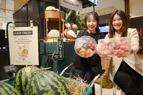 롯데백화점 광복점 식품관에서 모델들이 현장에서 즉시 컷팅한 과일을 들어보이고 있다. /사진=롯데백화점 광복점