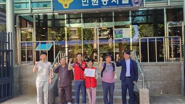 KOK재단 피해 관련 단체들과, 송갑용 씨로부터 형사고소·민사소송을 당한 기자들이 송 씨에 대한 무고·소송사기 혐의 고소장을 들고 사진을 찍고 있다. /사진=김준하 기자