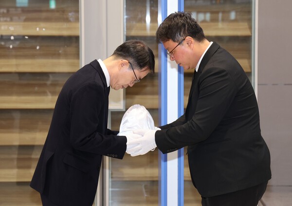 장진욱 경찰청 과학수사운영계장(오른쪽)이 21일 인천국제공항을 통해 캄보디아 범죄 단지에서 고문 후 살해된 20대 대학생 박모(22)씨의 유해를 송환한 뒤 안중만 경북경찰청 형사기동대장에게 인계하고 있다./사진=연합뉴스